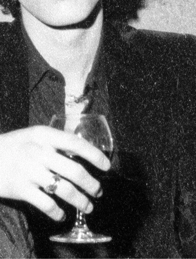 Un homme en veste de velours tient un verre de vin au comptoir du bar Canon