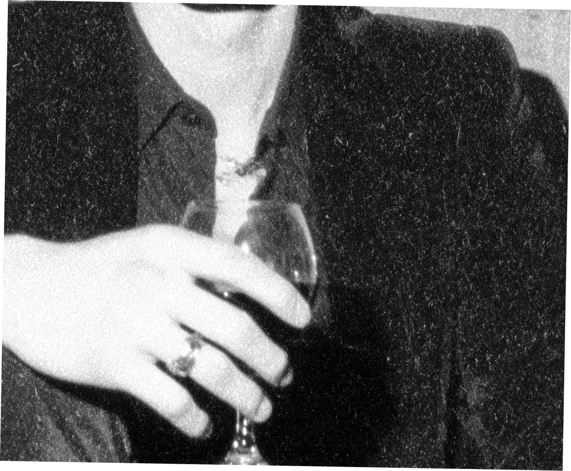 Un homme en veste de velours tient un verre de vin rouge